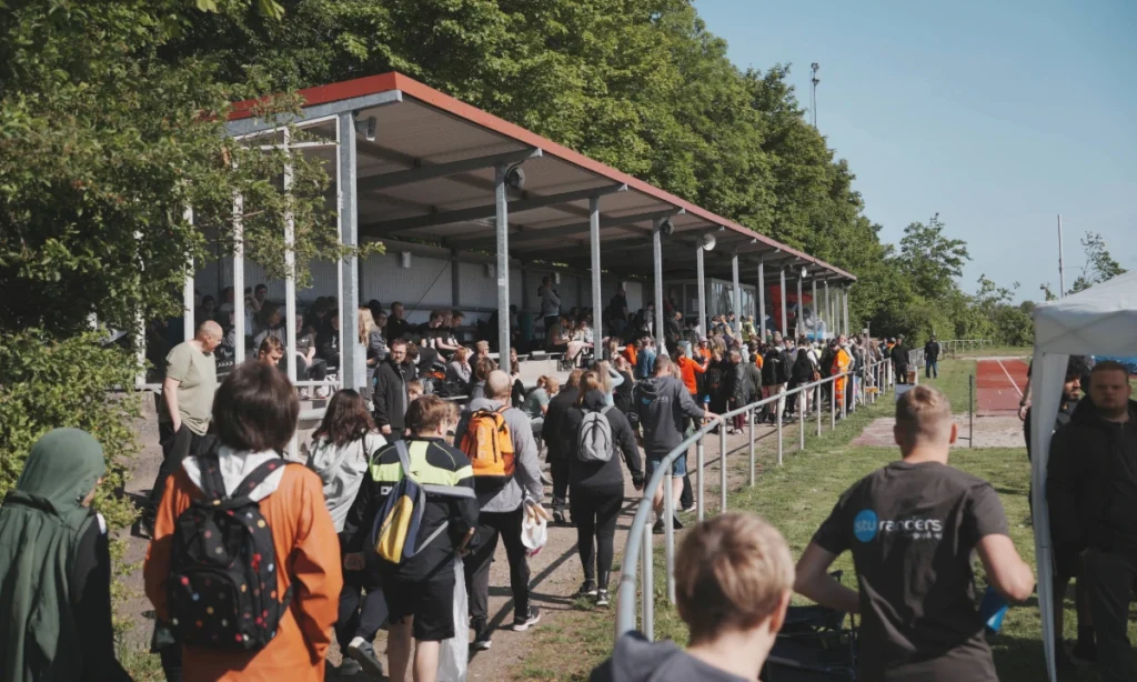 Fyldte tribuner og mange deltagere på Langvang Stadion under STU atletikstævnet, der viser det store fremmøde af unge, personale og frivillige til arrangementet.