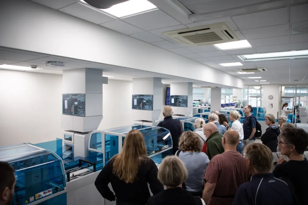 Publikum til Åbent Hospital ser hospitalets avancerede laboratorium og lærer om blodprøvers rejse i sundhedsvæsenet.